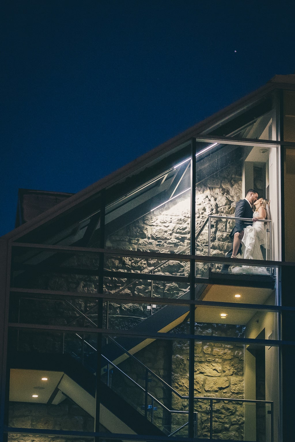 bride and groom kissing in the stairs at the Cambridge Mill
