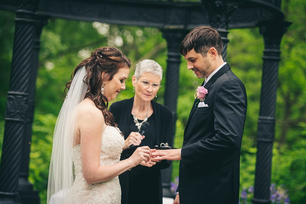bride and groom exchanging rings at wedding ceremony 