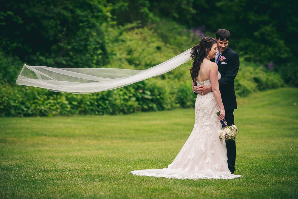 bride and groom posing for wedding photo in the valley at the Elmhurst Inn  with veil blowing in the wind