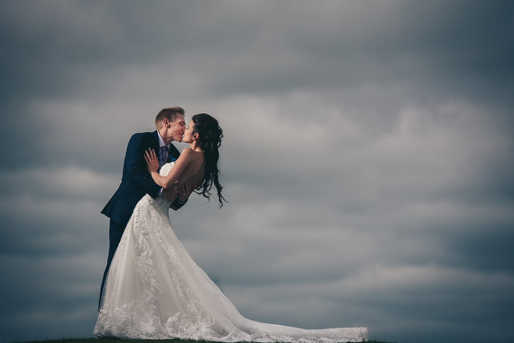 bride and groom kissing in the sky 