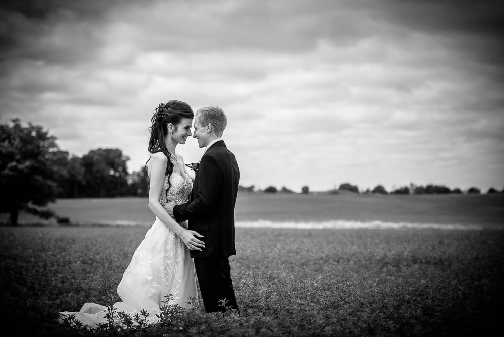 bride and groom in field in black and white at Mitchel golf club