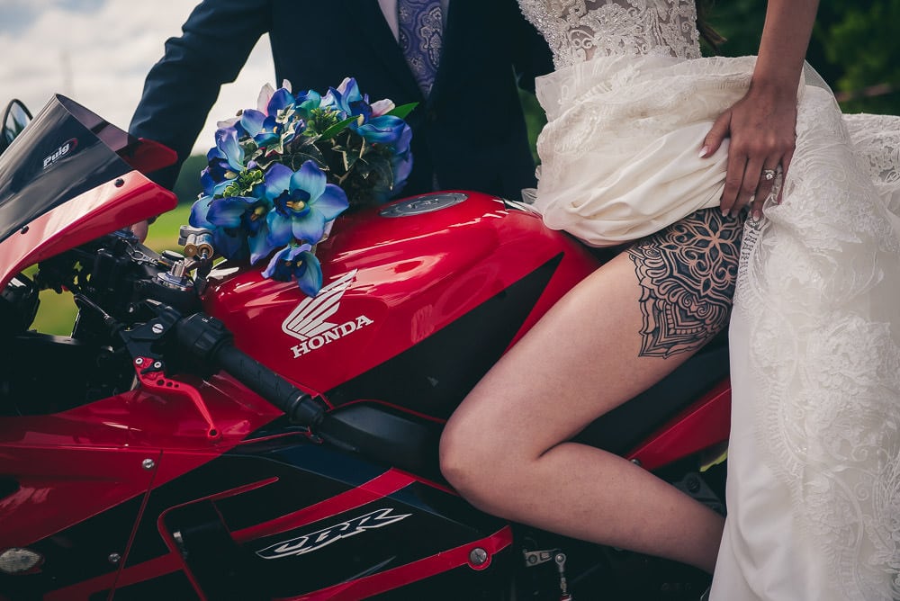 wedding photo showing off brides tattoo on motorcycle at Mitchell golf course
