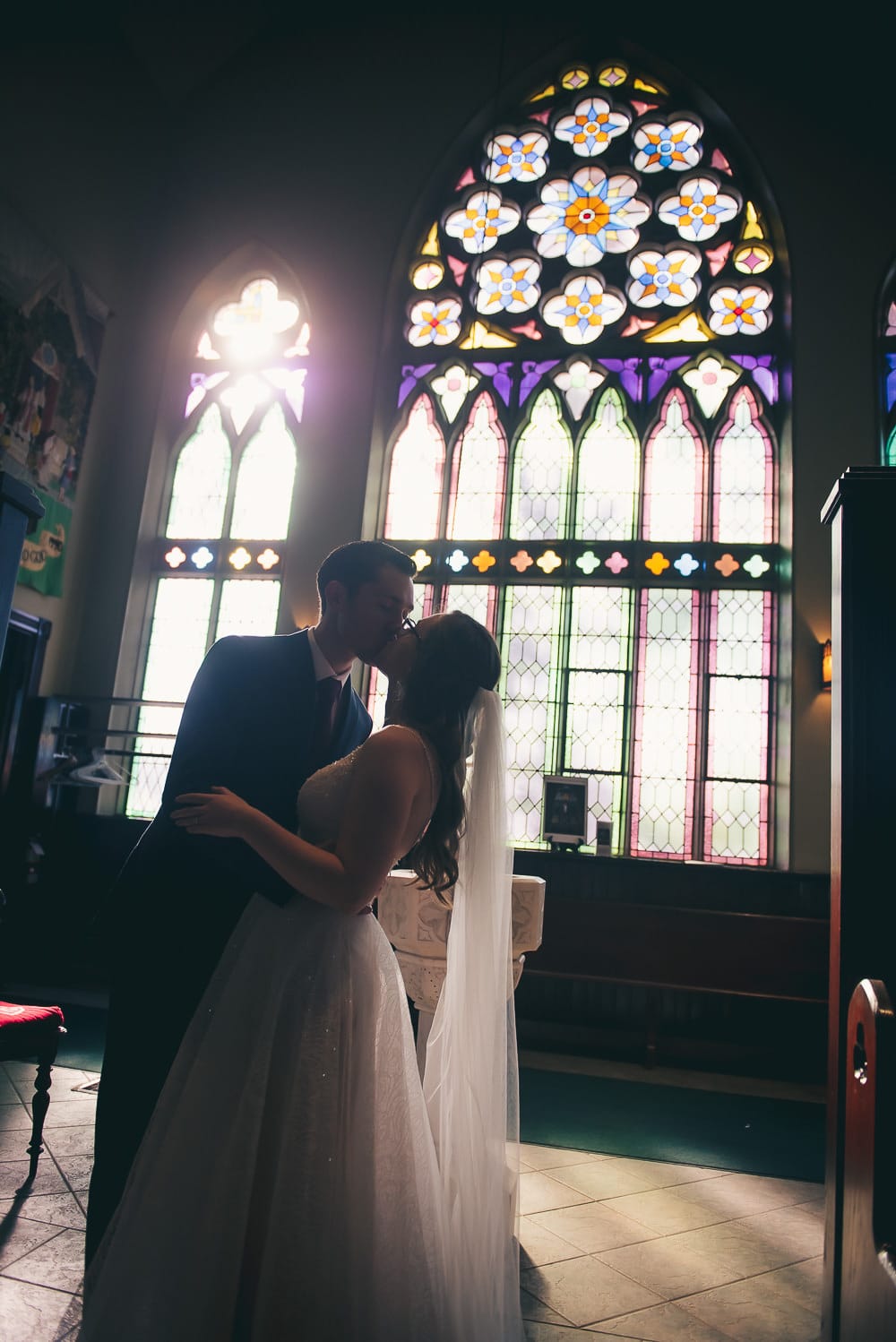stain glass window shilloute photo of bride and groom at wedding