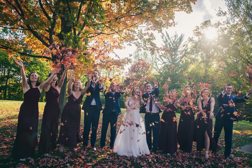 fall wedding photo wedding party throwing leaves